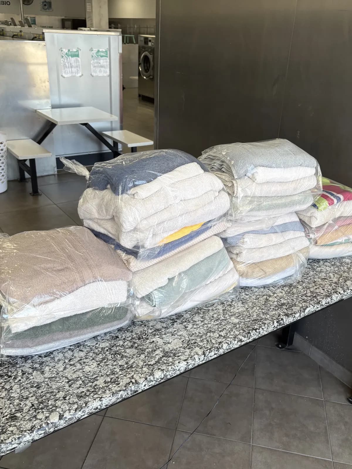 Folded and bagged commercial linens ready for pickup at CleanMax Laundromat in Pomona, CA