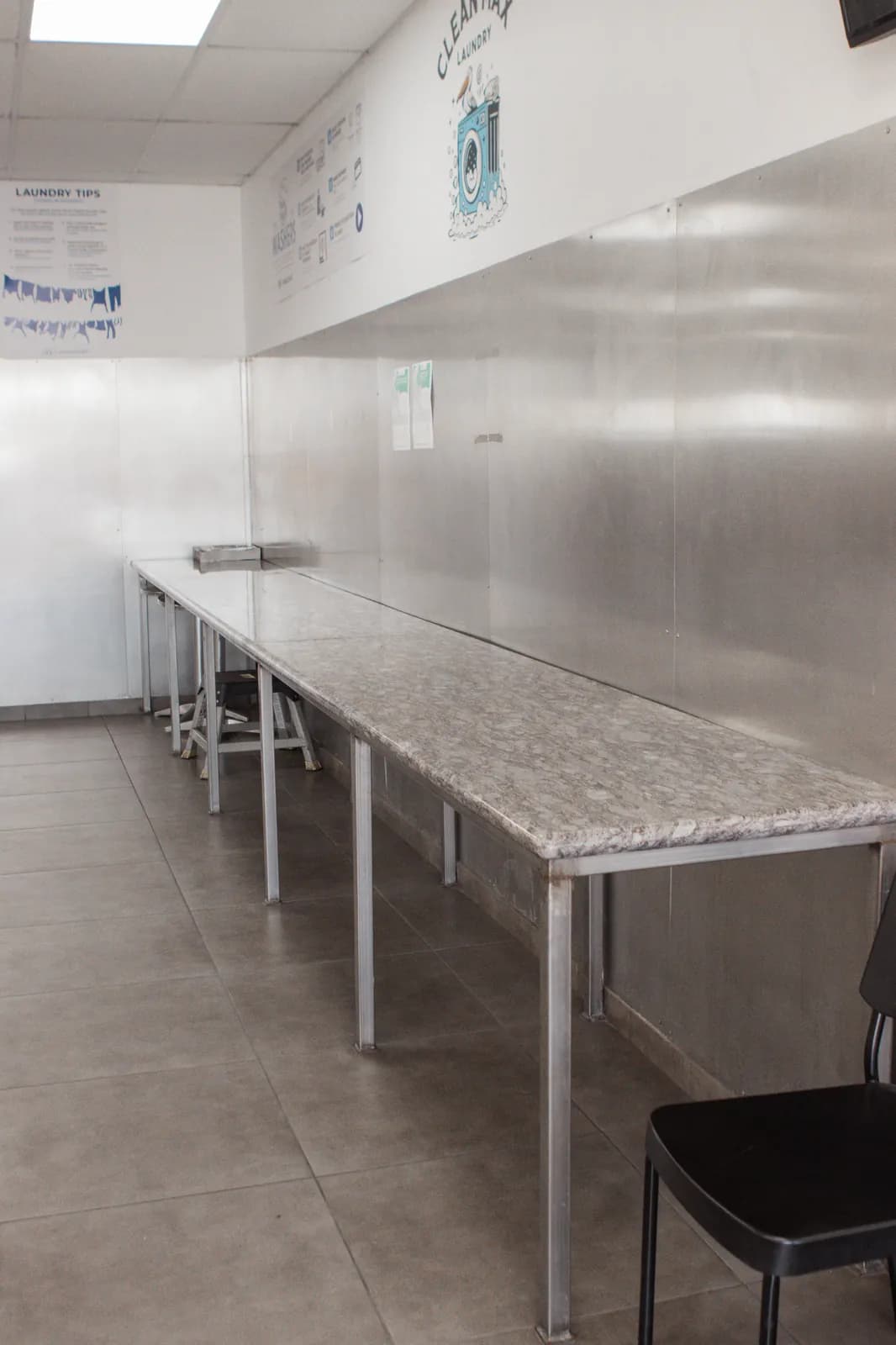 Commercial-capacity folding counter with laundry tips signage at CleanMax Laundromat Pomona, CA