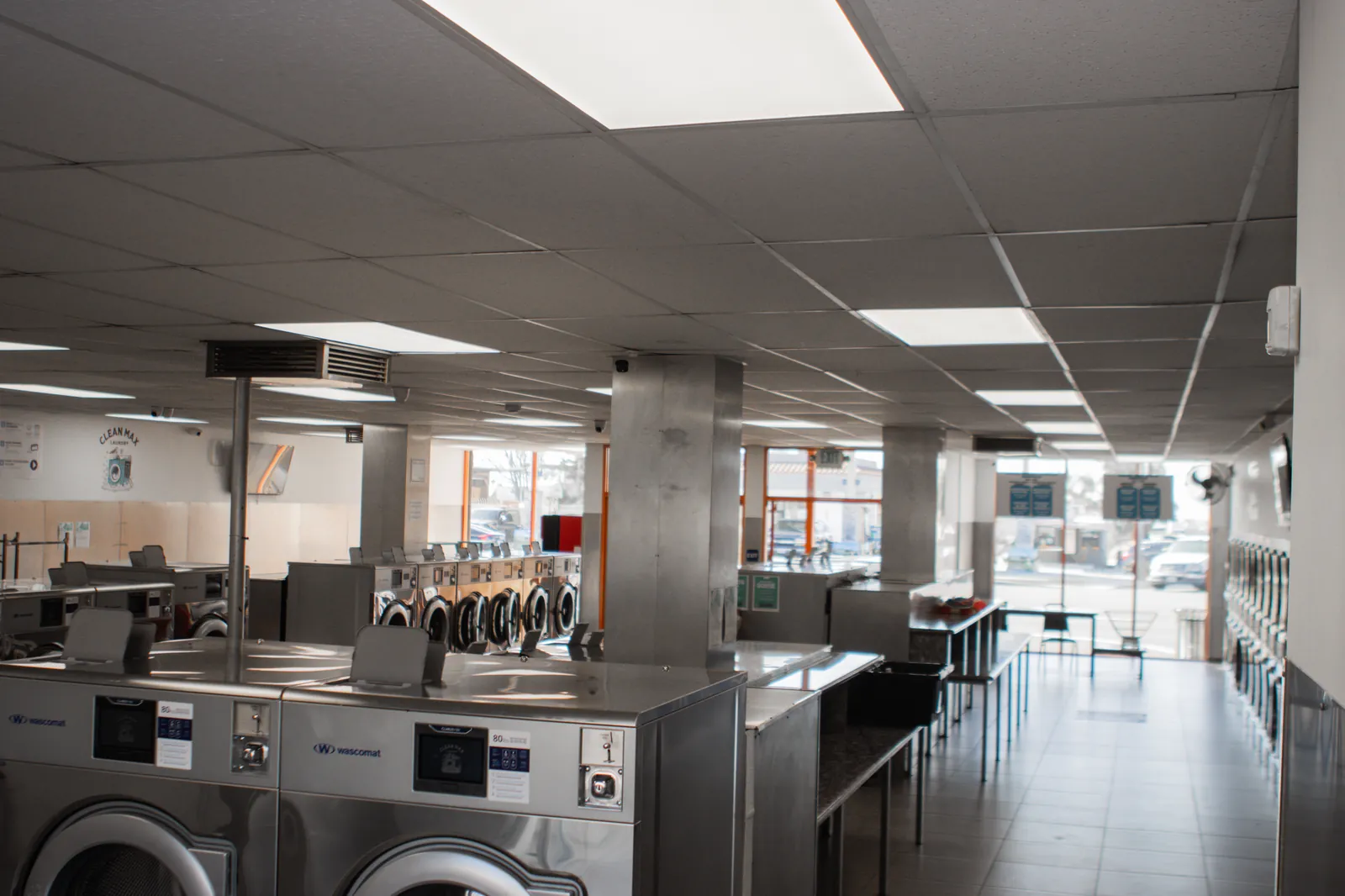 CleanMax Laundromat interior in Pomona, CA β spacious, bright, rows of modern Wascomat washers and IPSO dryers