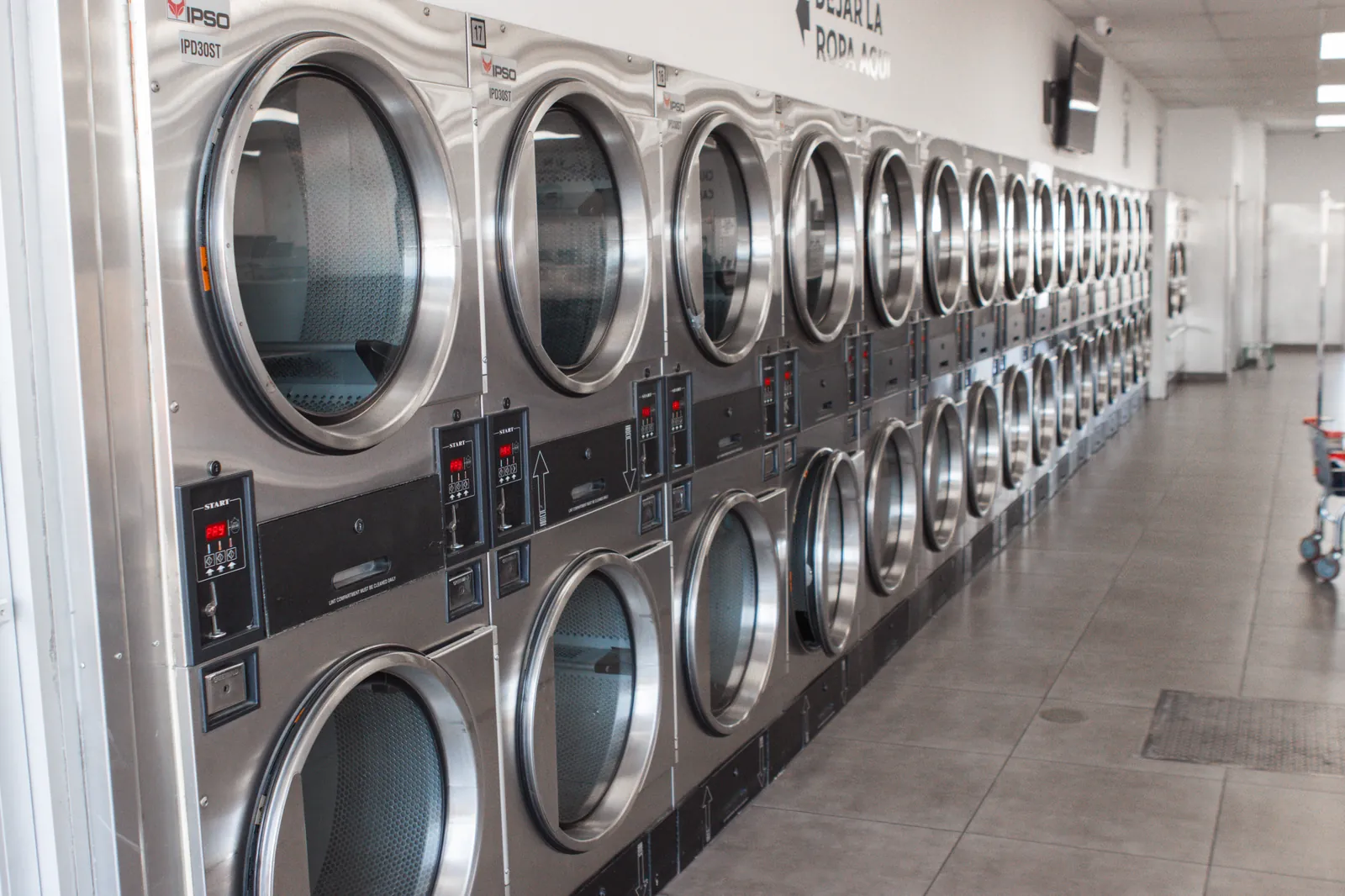 IPSO stack dryers with bilingual Spanish and English signage at CleanMax Laundromat Pomona